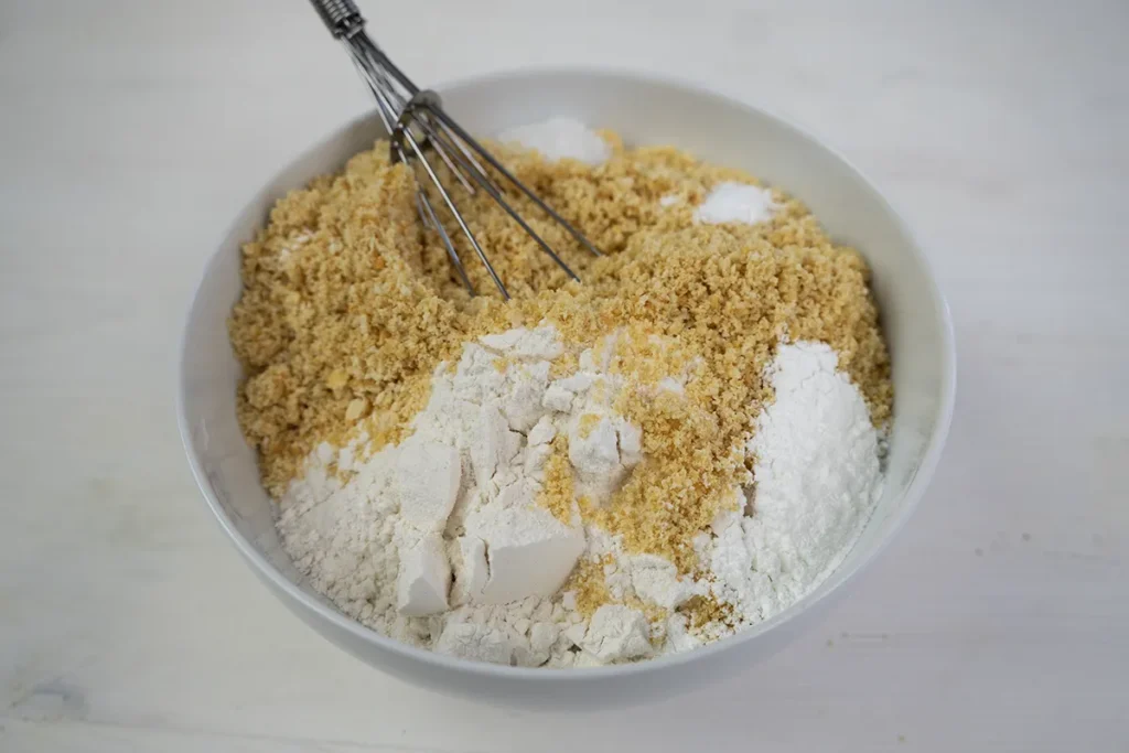 Whisking together Ritz cracker crumbs, flour, salt, baking soda and baking powder.