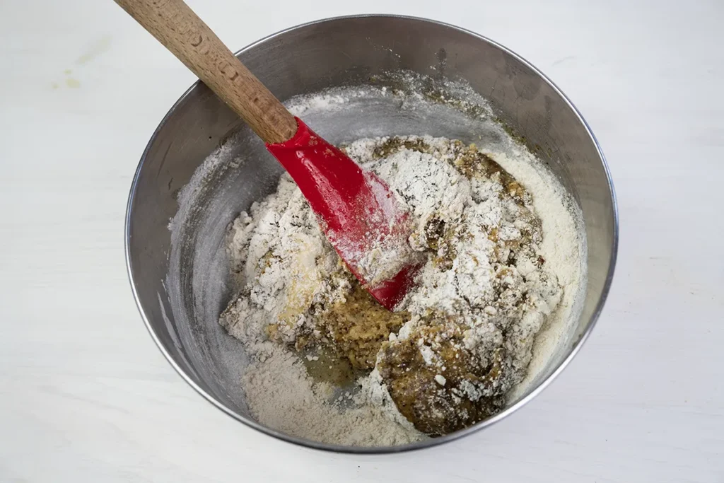 Folding in the dry ingredients into the wet ingredients for kitchen sink cookie dough.
