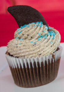 Cookies & Cream cupcake with blue sprinkles and shark fin-shaped Oreo cookie topper.