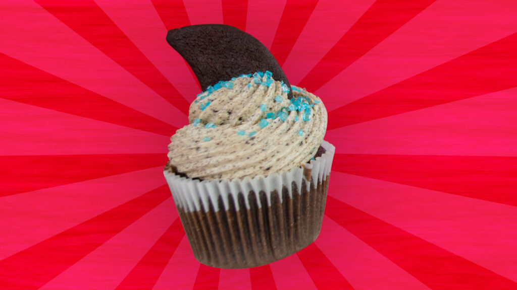 Oreo Cookies 'n' Cream cupcake with Oreo buttercream frosting, blue sprinkles, and a shark fin-shaped Oreo cookie topper.