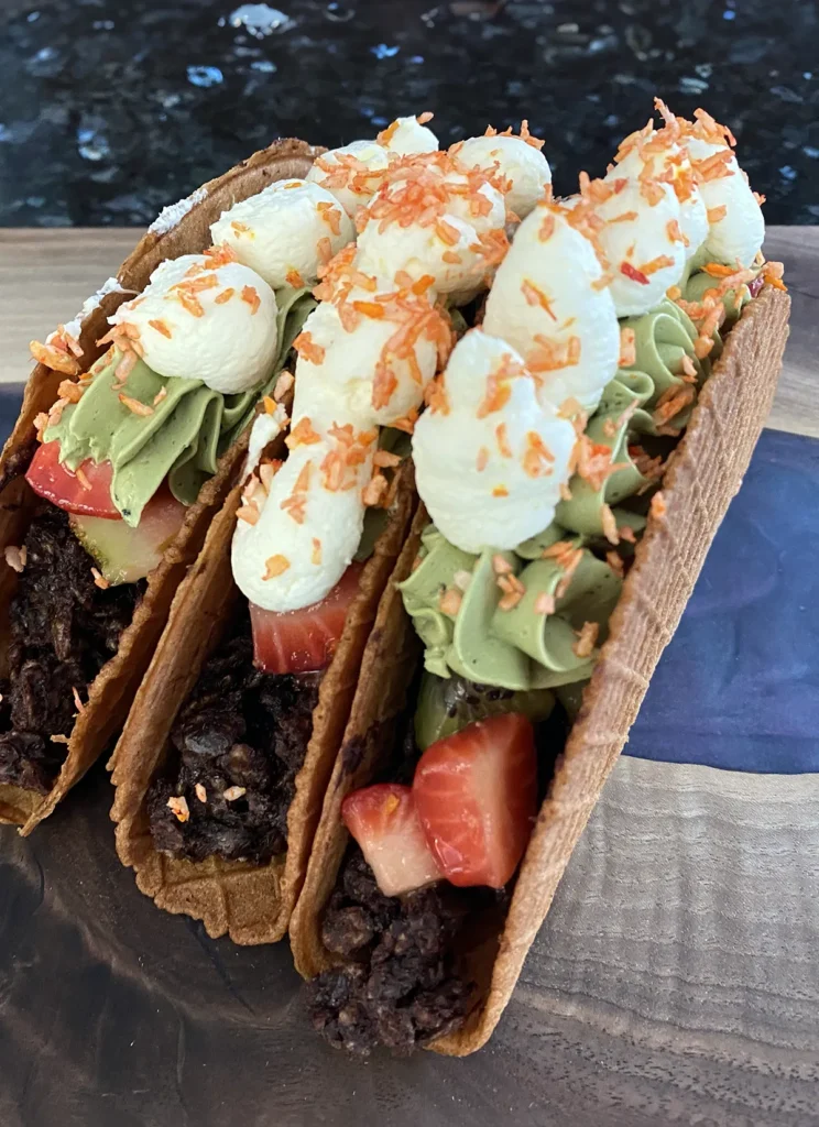 Three dessert tacos standing up side by side.