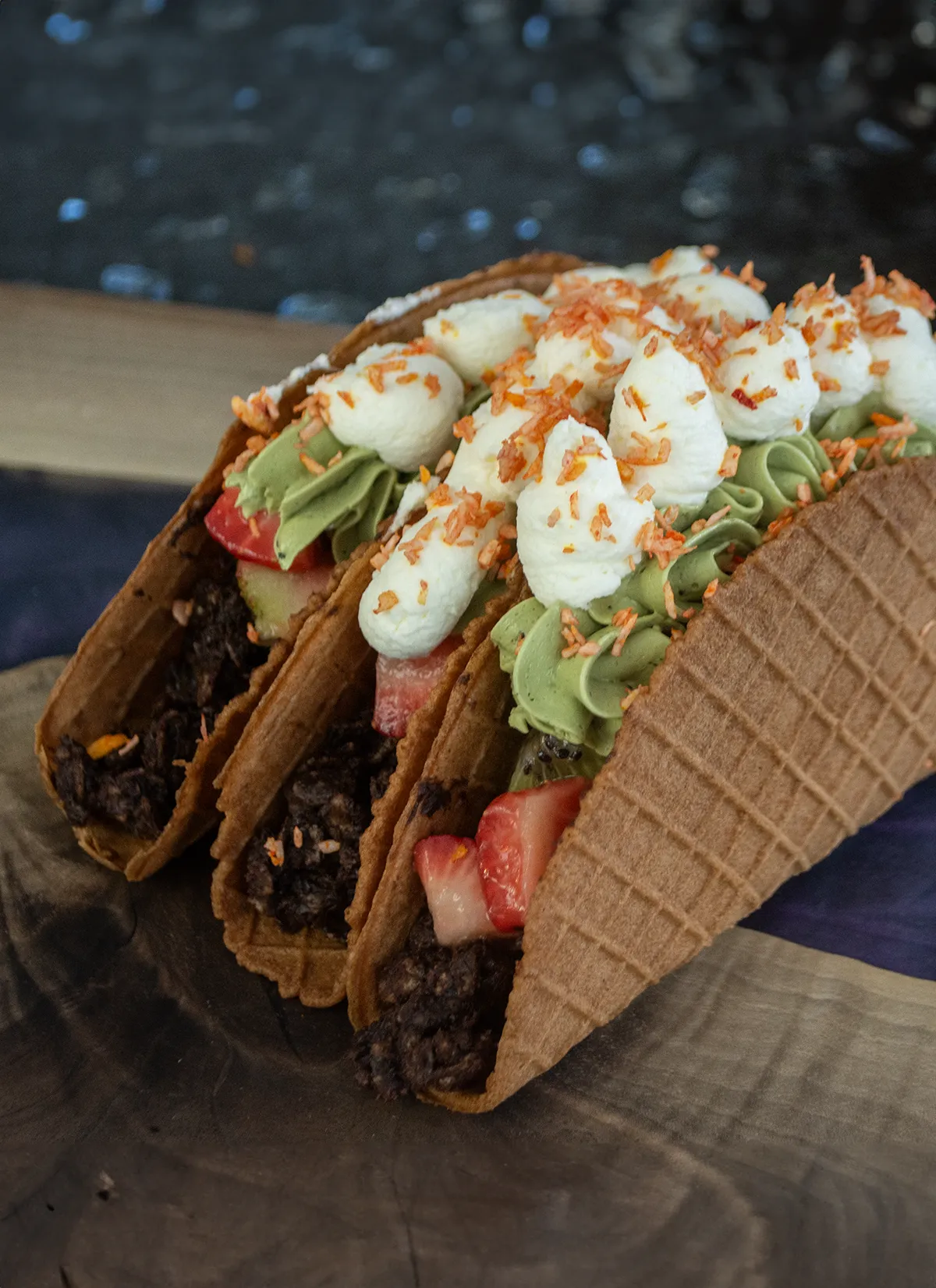 Three dessert tacos standing up side by side.