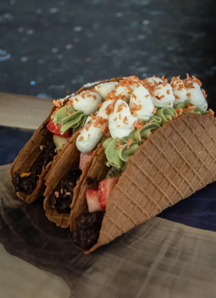 Three dessert tacos standing up side by side.