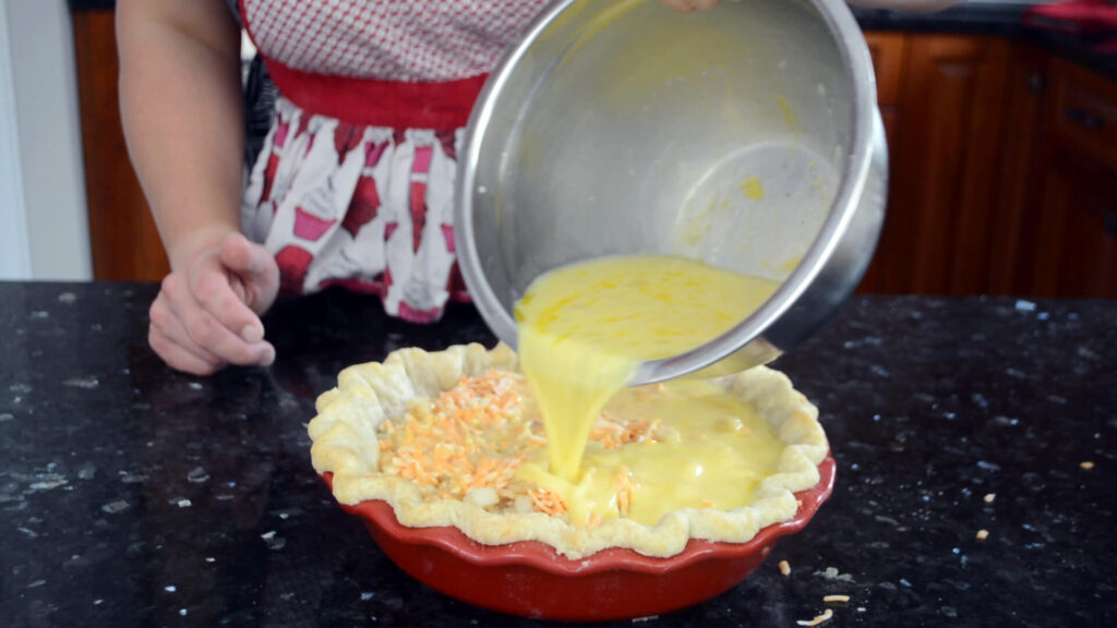 Pouring egg mixture into Deep Dish Breakfast Pie