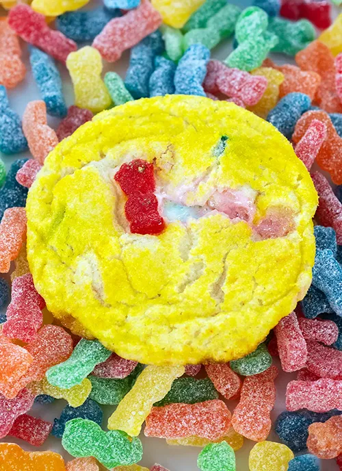 A Sour Patch Kids cookie on a pile of Sour Patch Kids candies.