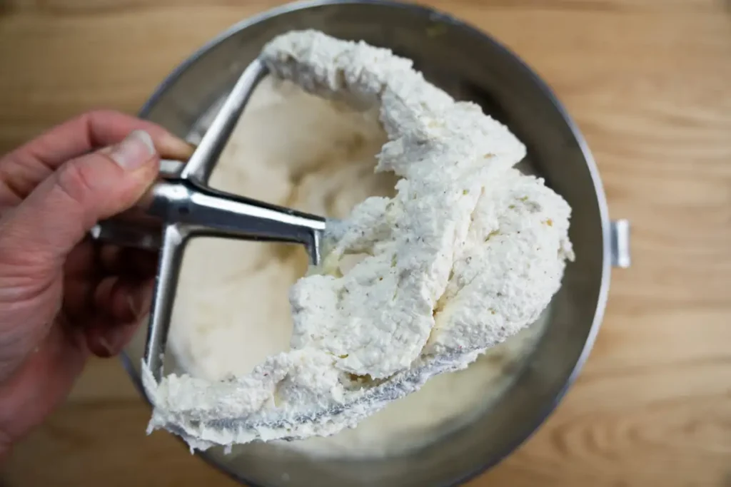 Browned butter creamed with granulated sugar until light and fluffy, shown on a mixer paddle.