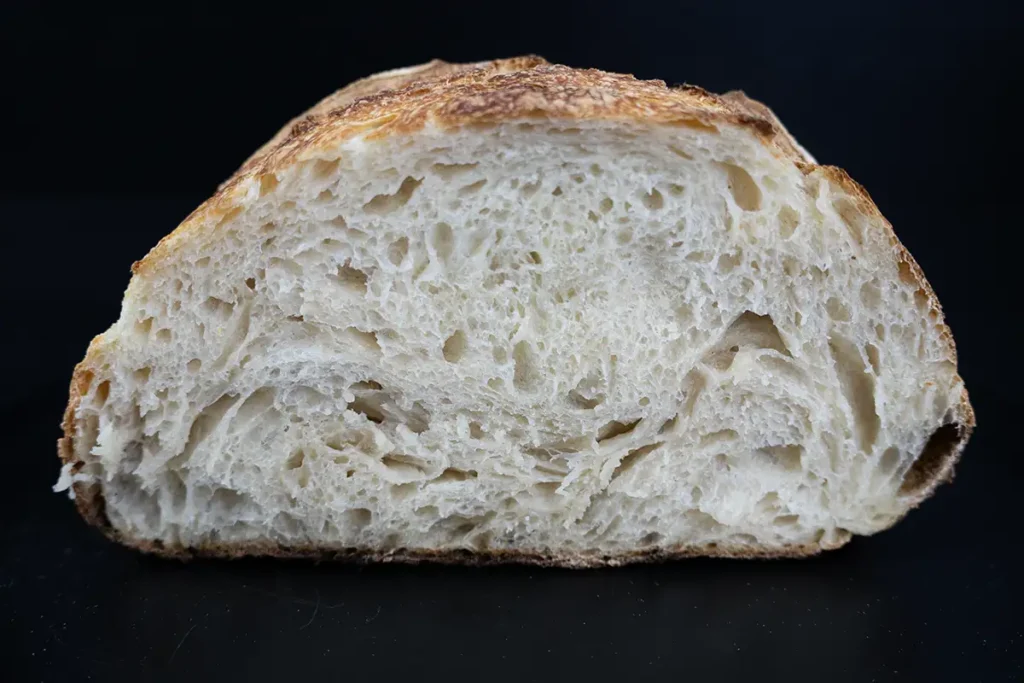 Cross-section of a loaf of sourdough bread, showing the interior crumb.