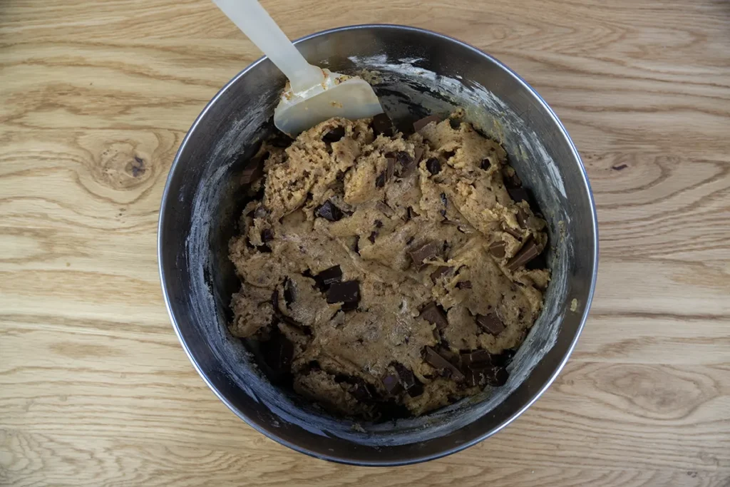 Sourdough chocolate chip cookie dough in a large metal mixing bowl.
