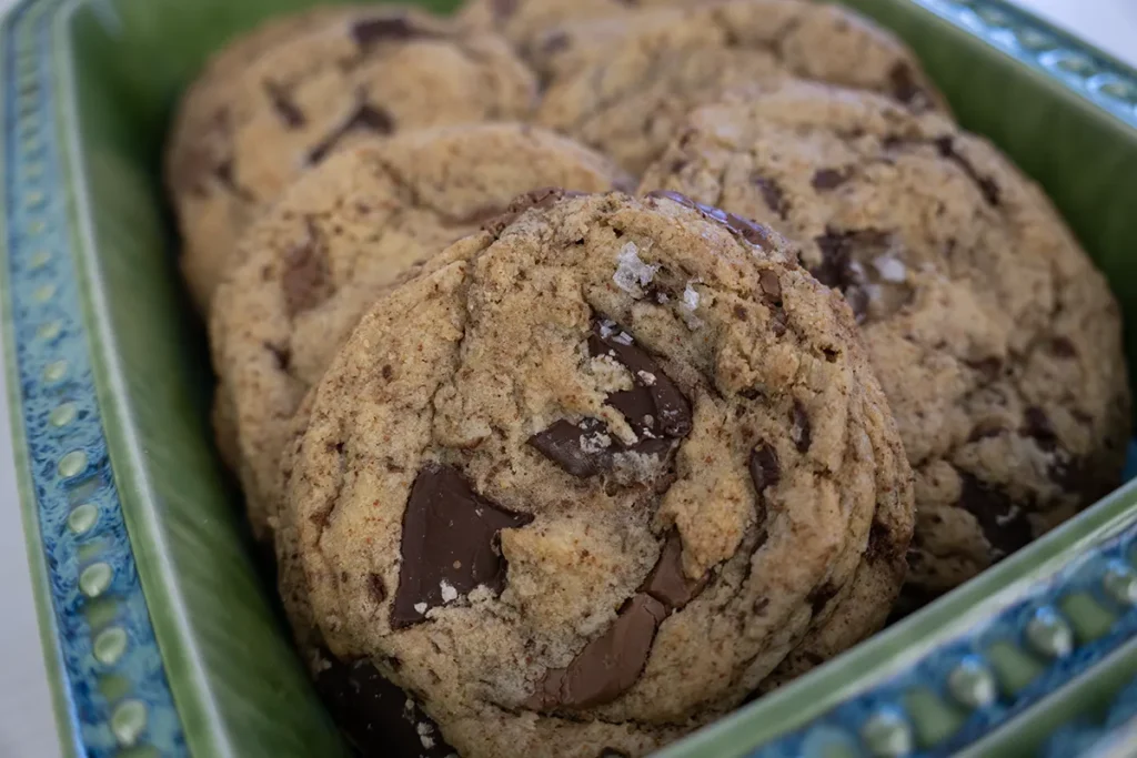 Sourdough chocolate chip cookies in a ceramic dish.