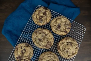 Sourdough chocolate chip cookies on a wire rack.