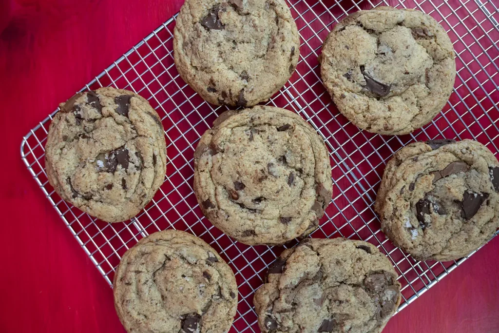 Sourdough chocolate chip cookies cooling on a wire rack.