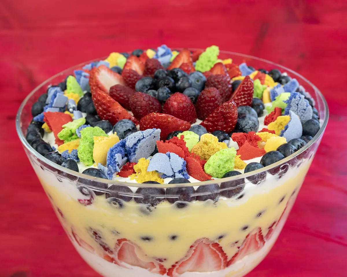 Fresh fruit trifle with macaron crumbles, fresh berries, lemon curd, and whipped cream.