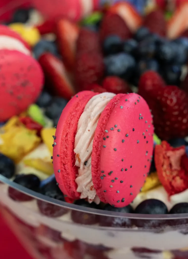Close-up of a macaron on top of a fresh fruit trifle.