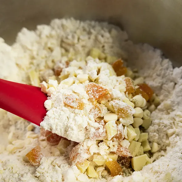 Adding dried apricots and white chocolate to the scone dough.