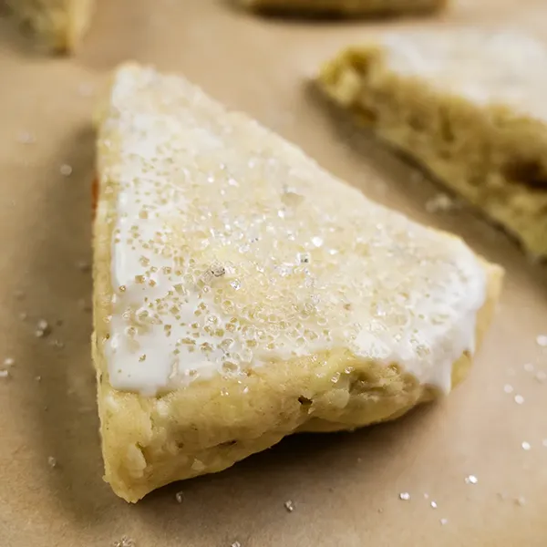 Coarse sugar sprinkled on top of a raw scone.