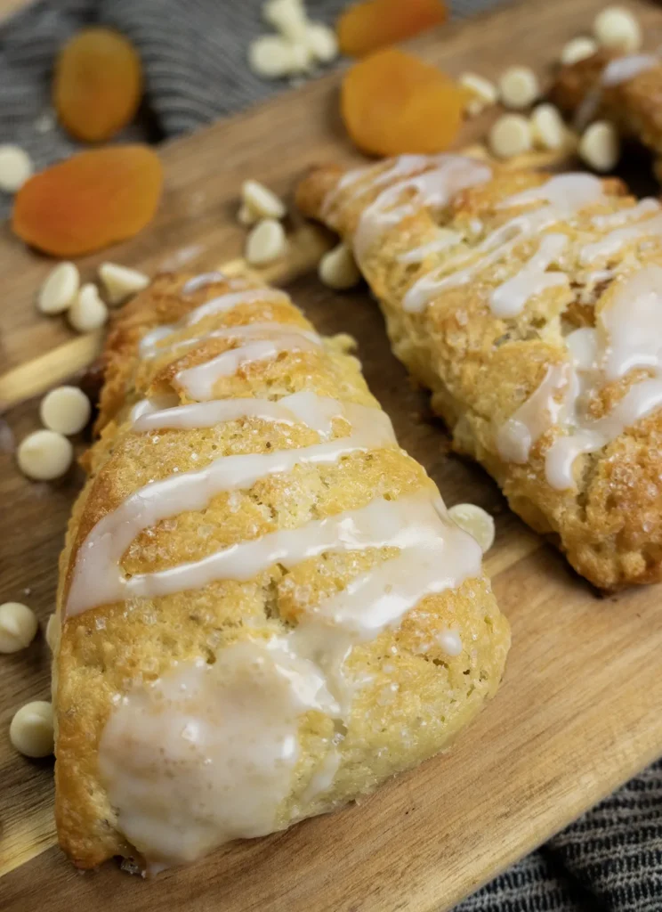 Sourdough apricot & white chocolate scones on a wooden board.