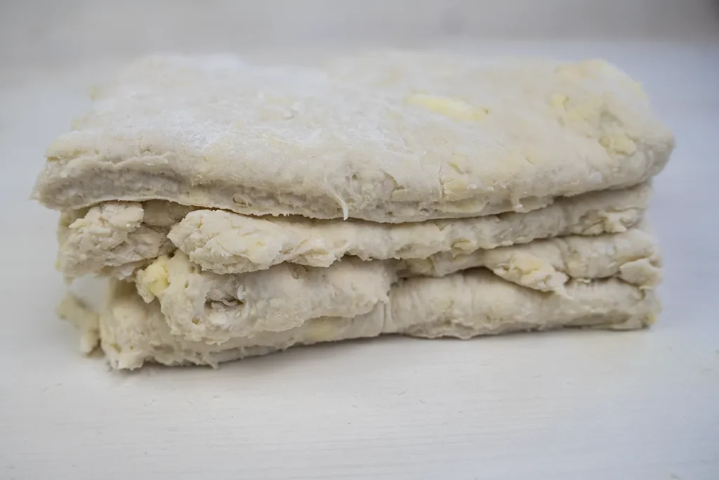 A stack of sourdough biscuit dough in layers.