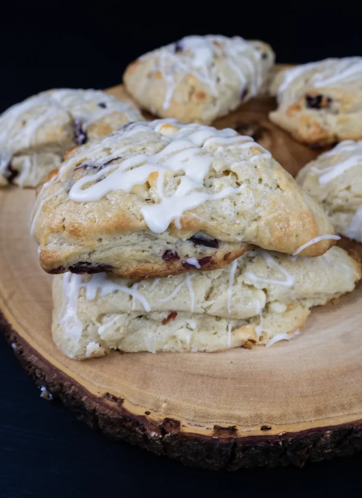 Stack of glazed scones on a wooden tray.