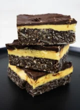 A stack of Nanaimo bars on a plate.