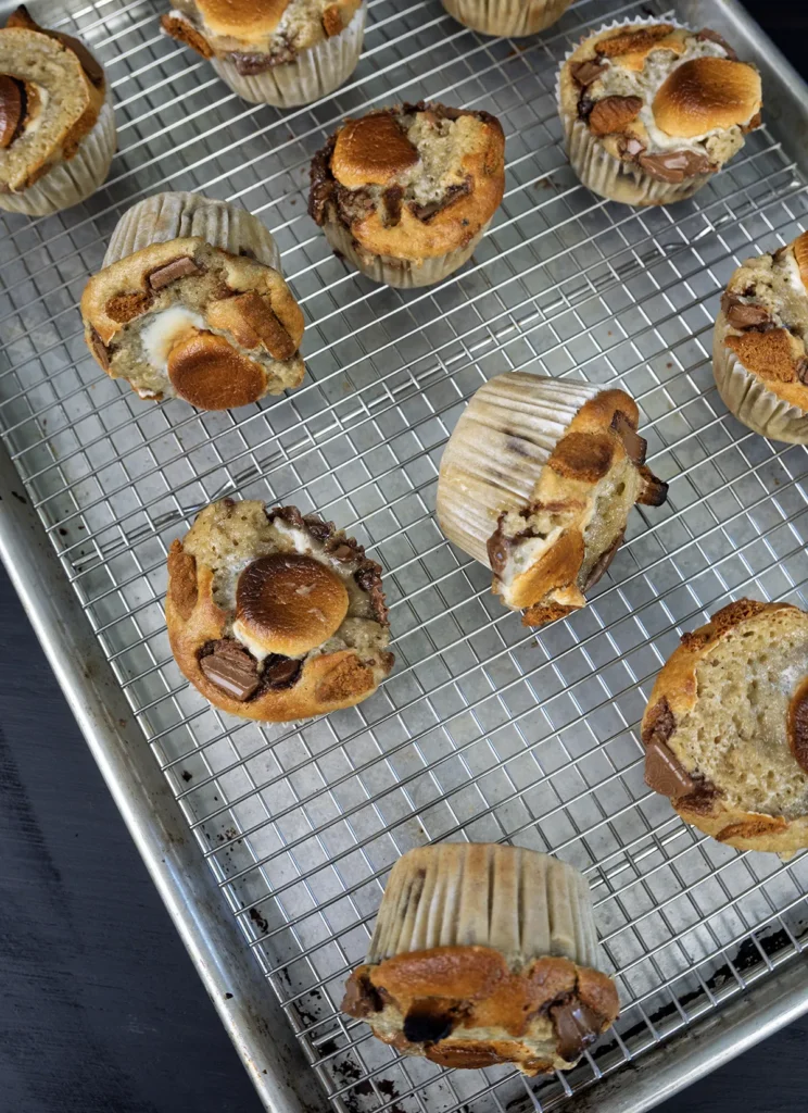 Sourdough banana s'mores muffins arranged on a wire cooling rack.