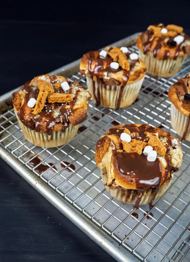 Sourdough banana s'mores muffins arranged on a wire cooling rack.