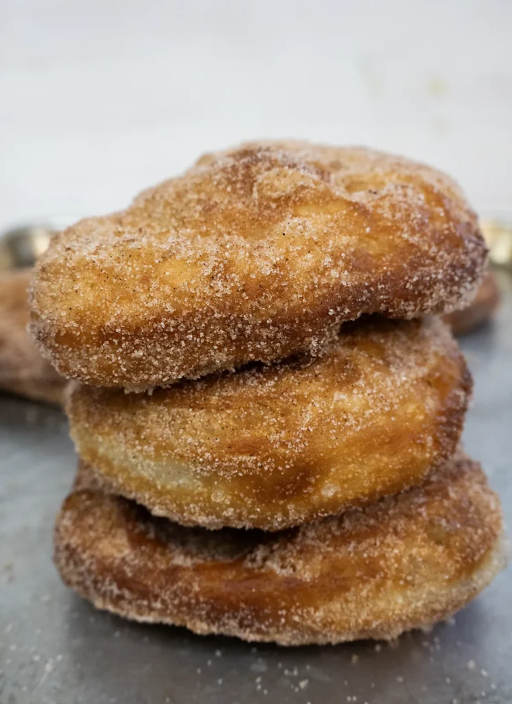 A stack of mini sourdough Beaver Tails on a baking sheet.