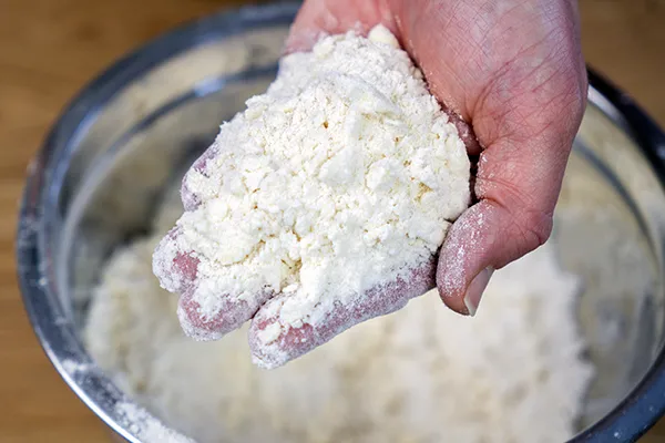 Cutting butter into scone dough until it resembles coarse bread crumbs.