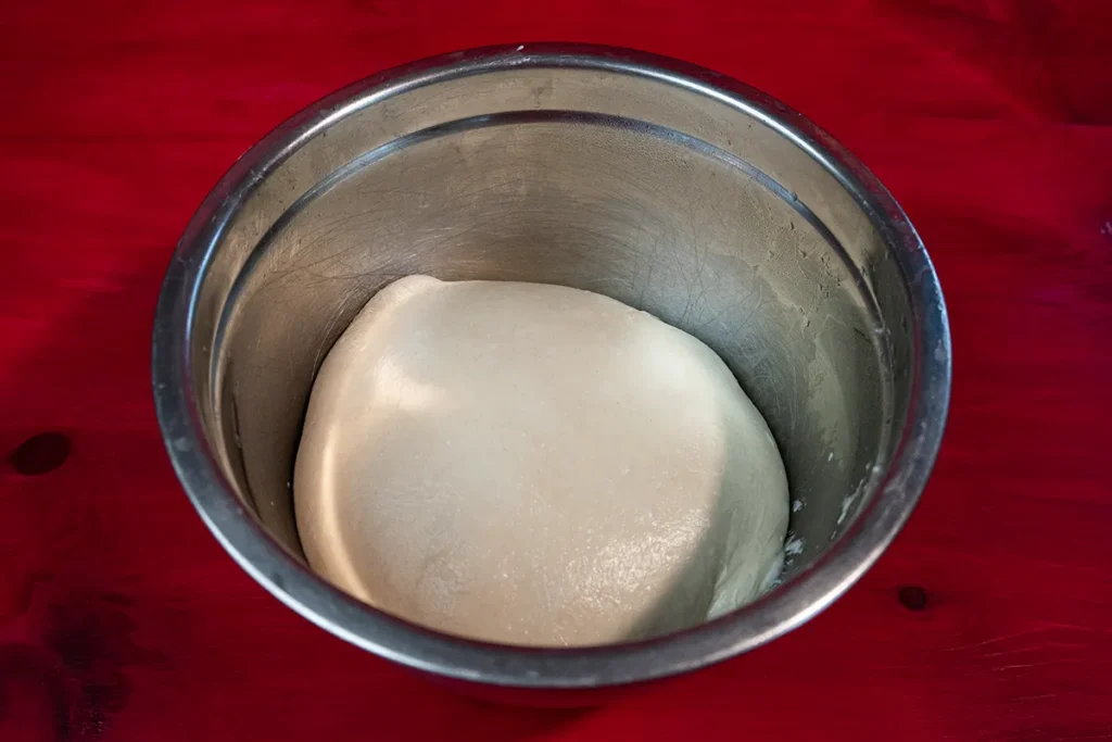 Sourdough Beaver Tail dough bulk fermenting in a lightly oiled bowl.