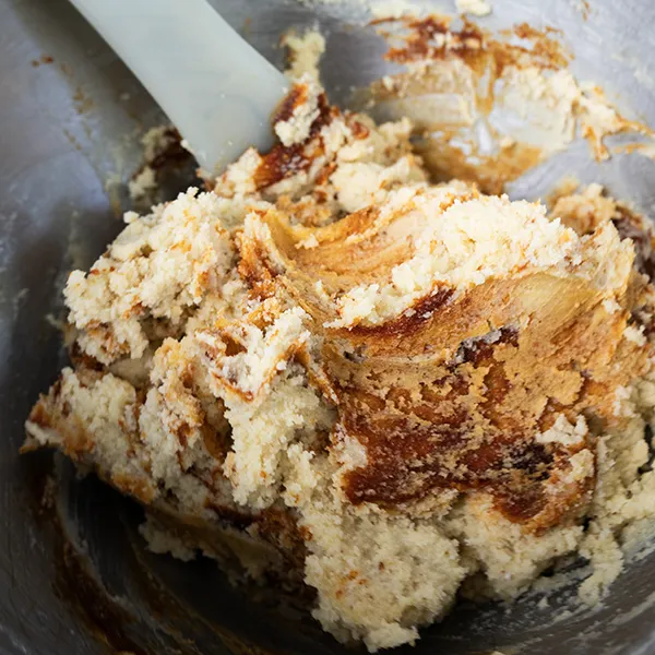 Marbling the gochujang caramel into the sourdough sugar cookie dough until barely combined, so that streaks of the gochujang caramel remain.