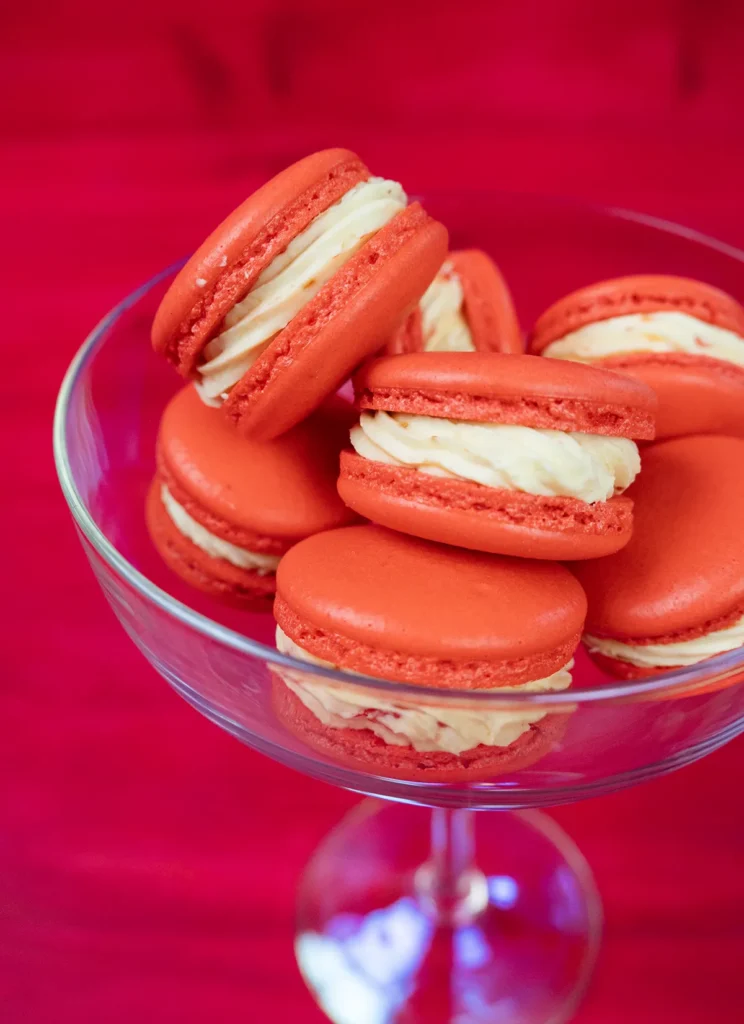 Strawberry Mango Tajín macarons in a stemmed glass.