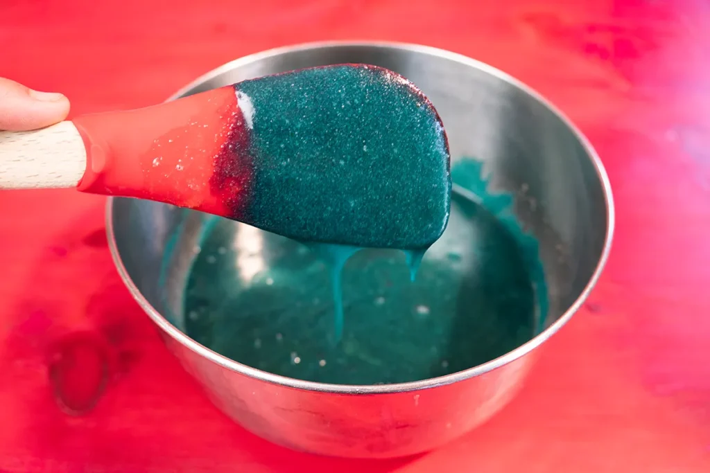 Adding eggs and blue food colouring to cookie monster cookie dough.