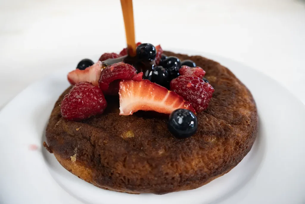 Drizzling maple syrup onto a mini skillet pancake.