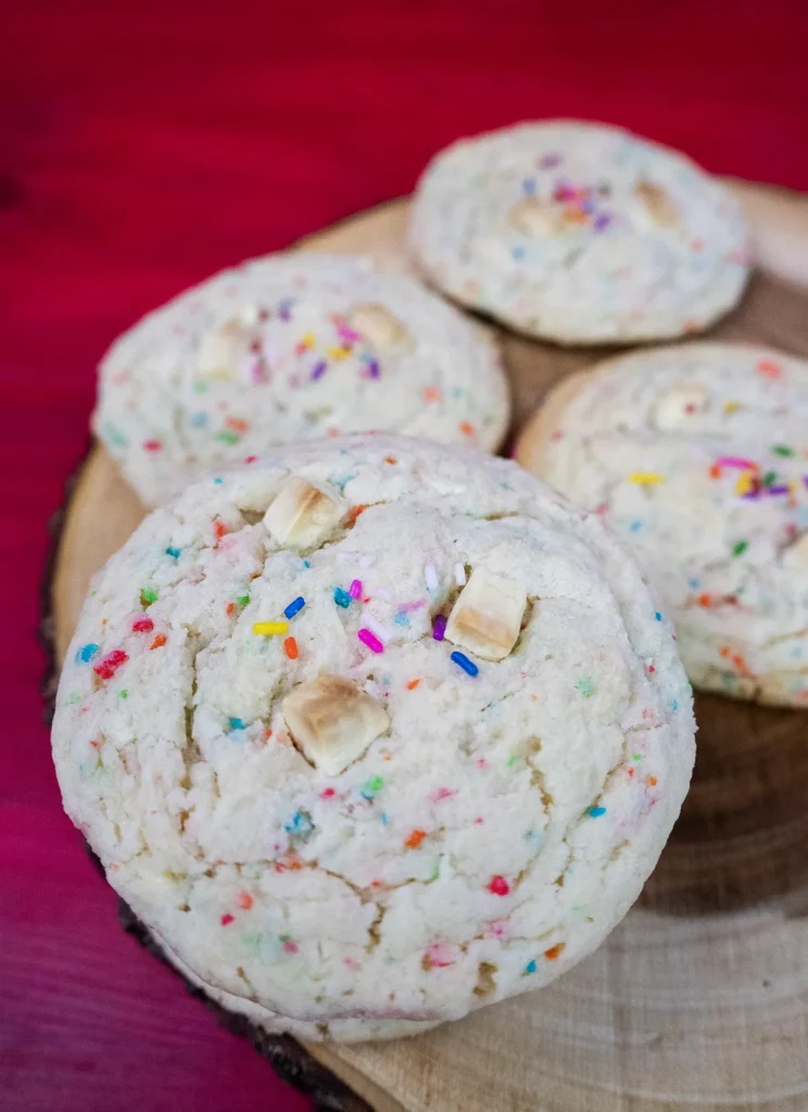 Funfetti cake mix cookies arranged on a wooden plate.