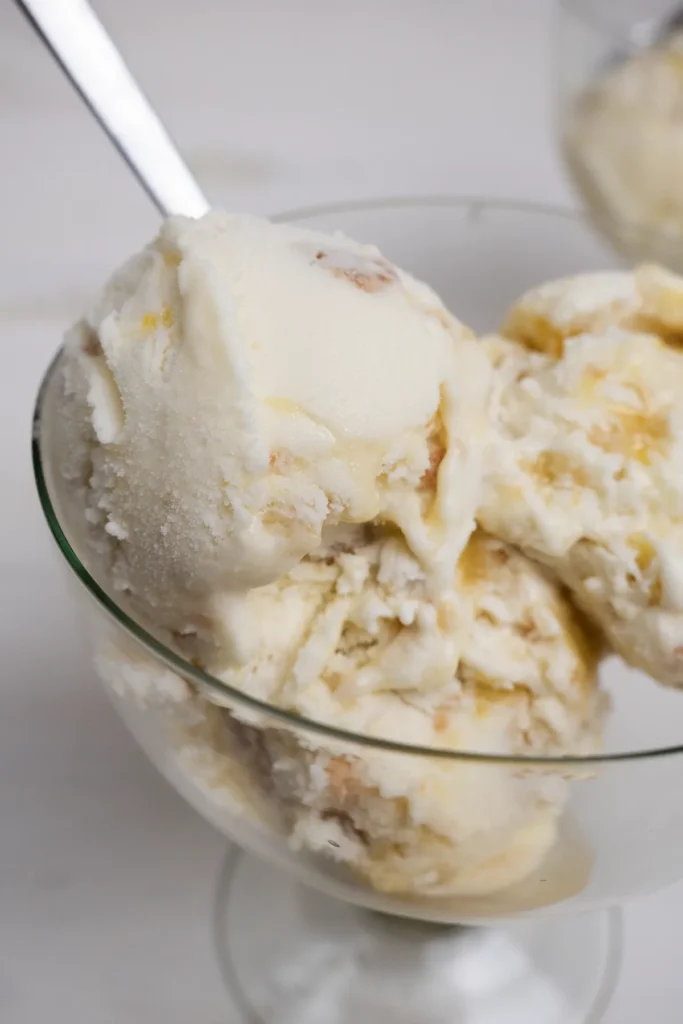 Scoops of lemon meringue pie ice cream in a glass.