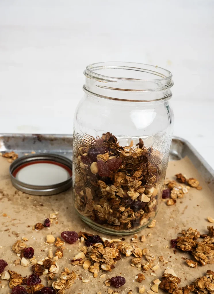 Open mason jar of sourdough peanut butter granola on a baking sheet.