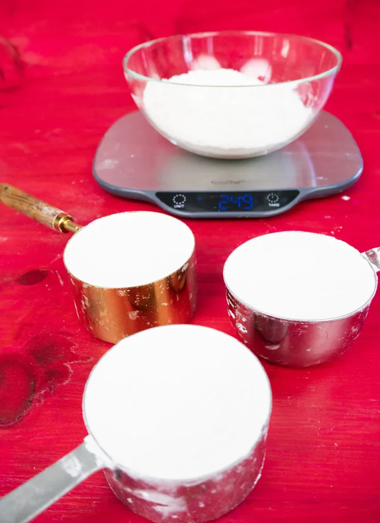 Measuring cups of flour on a digital scale.