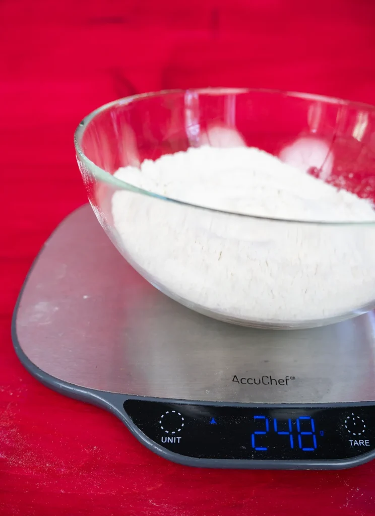 Weighing a bowl of flour on a digital scale.