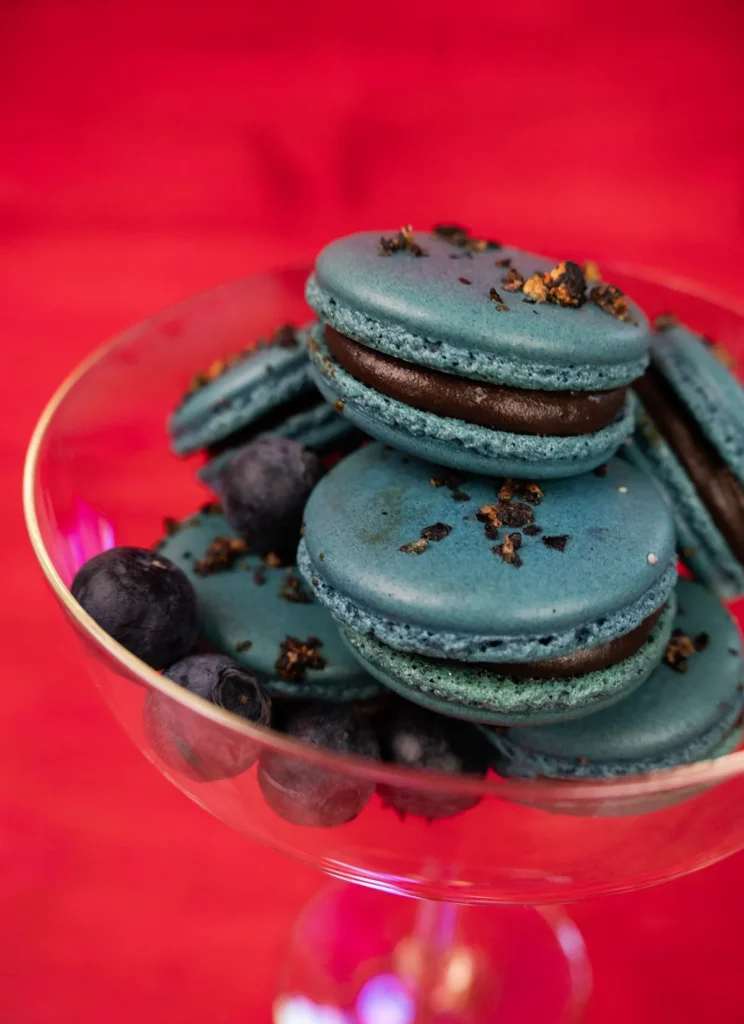 Blueberry macarons arranged in a glass.