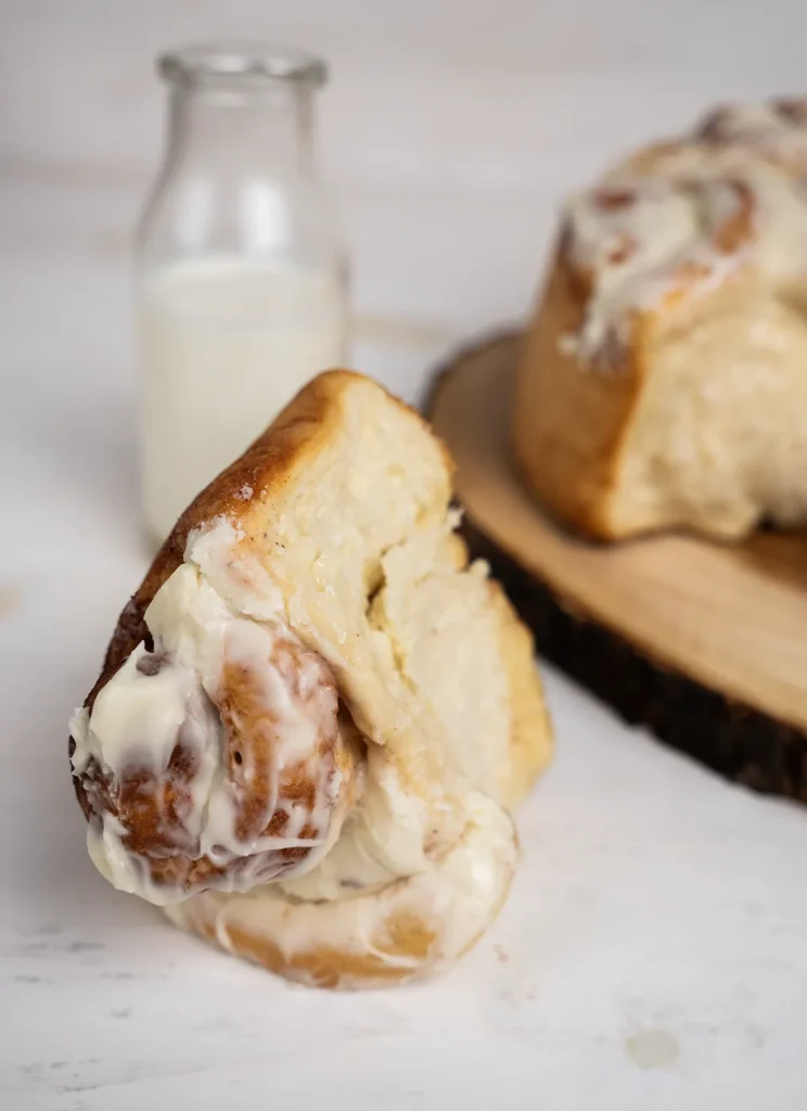 Jumbo cinnamon roll with cream cheese frosting, and a vintage milk bottle.