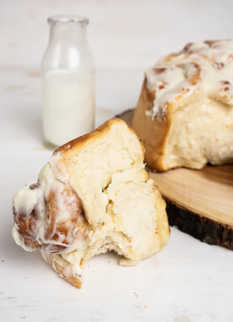 Jumbo cinnamon roll with cream cheese frosting, and a vintage milk bottle.