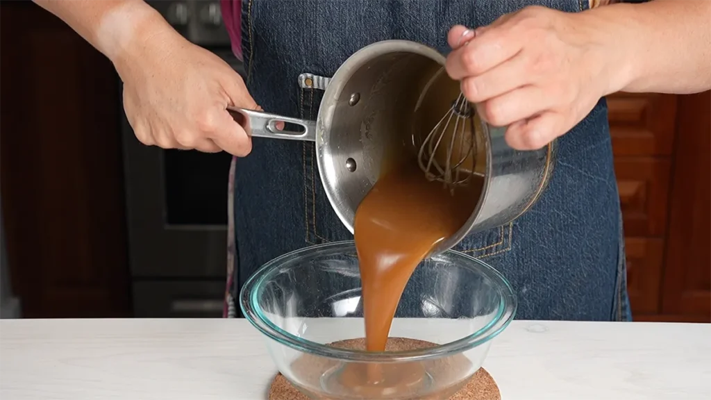 Pouring miso caramel into a heatproof bowl to cool down.