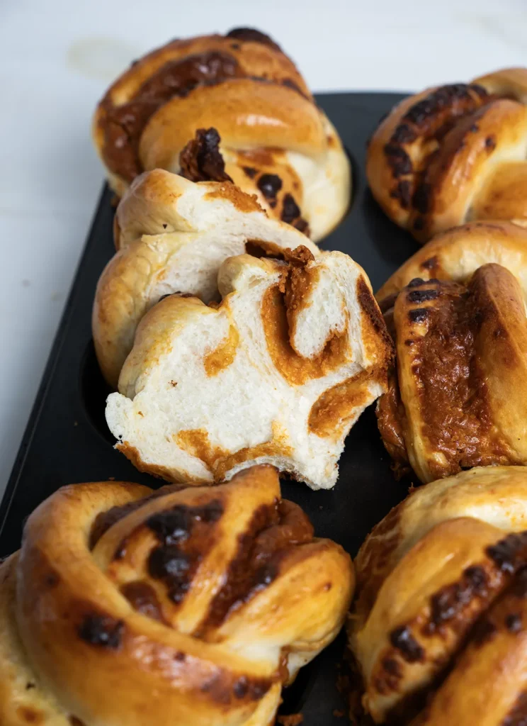 A group of gochujang cheddar mini babkas with one cut in half.