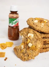 Stack of Mango Tajin oatmeal cookies in front of a bottle of Tajin.