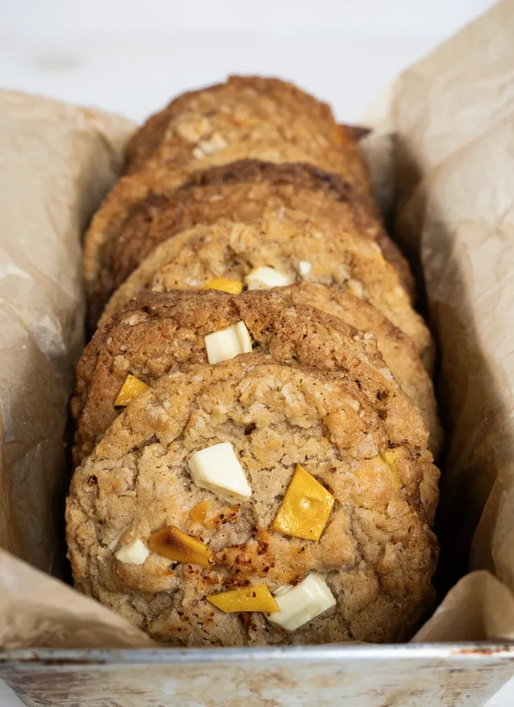 Mango Tajin oatmeal cookies lined up in a loaf pan lined with parchment paper.