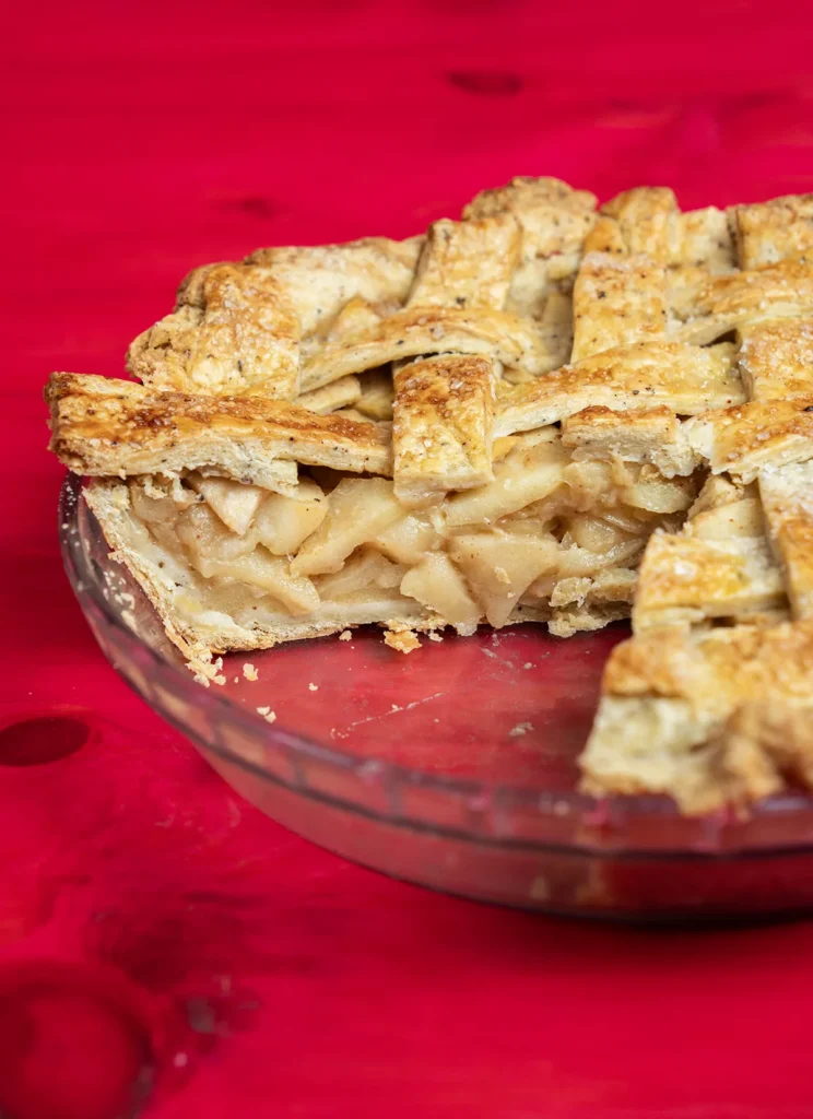 Miso caramel apple pie in a glass pie plate, with a slice taken out.