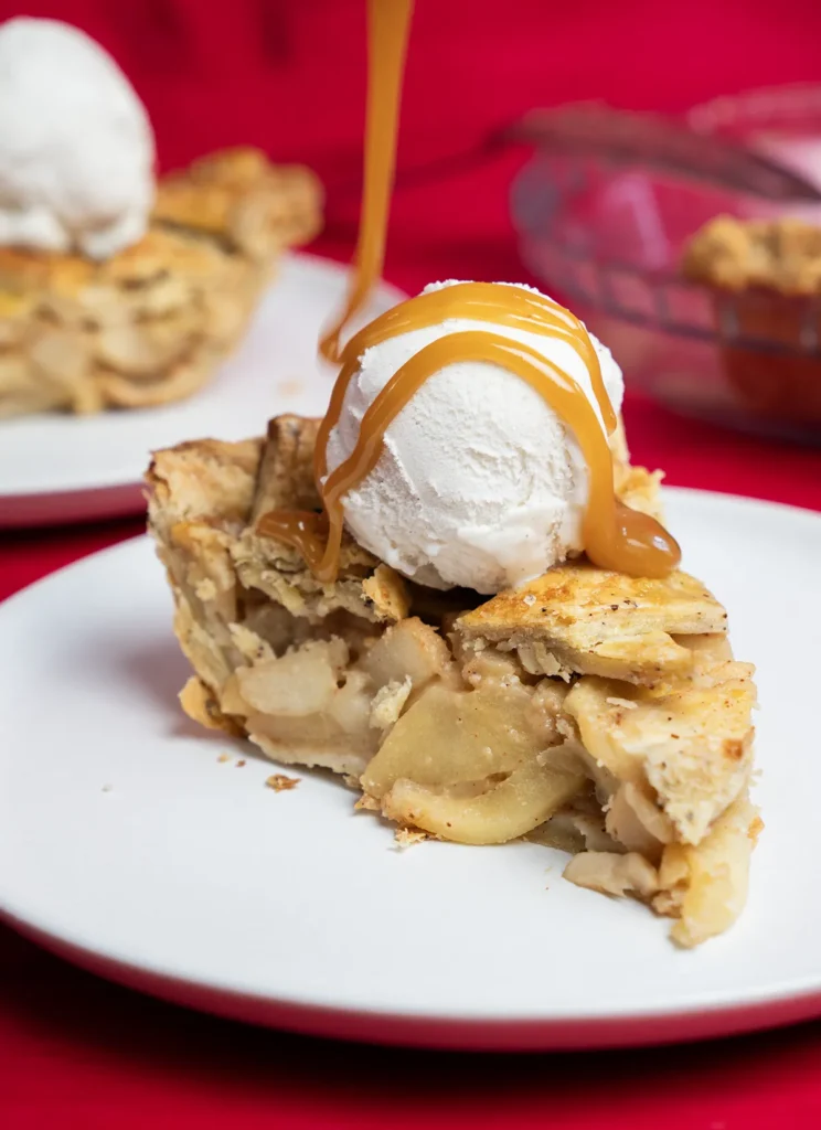 Slice of miso caramel apple pie with a scoop of ice cream.