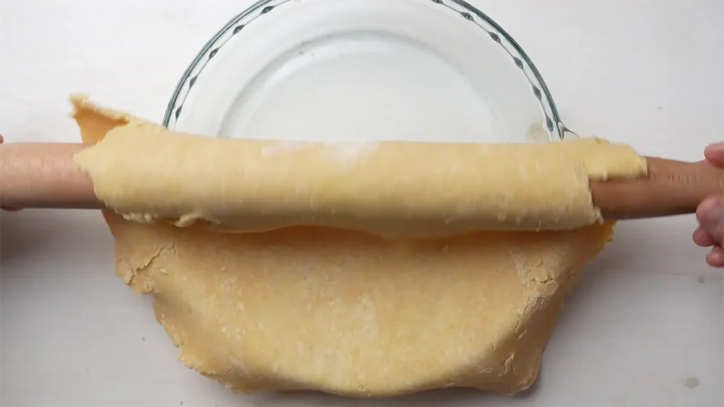 Gently rolling a brown butter pie crust into a pie plate.
