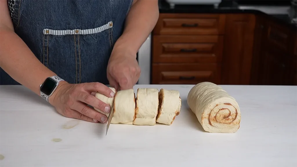 Cutting cinnamon rolls.