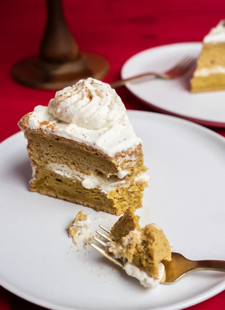 Slice of pumpkin spice latte tres leches cake on a plate, with a piece on a fork.