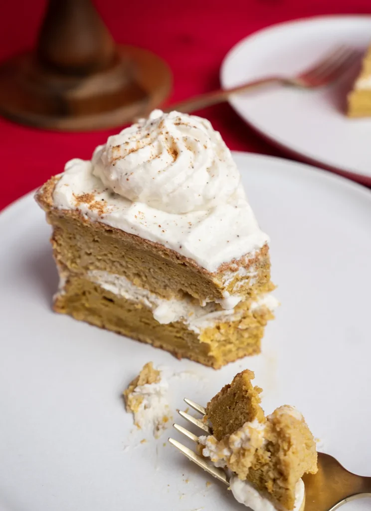 Slice of pumpkin spice latte tres leches cake on a plate, with a piece on a fork.